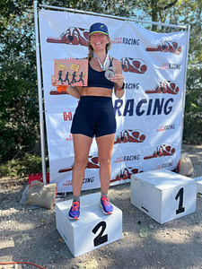 Heather on the 2nd place podium at the New Orleans UltraMarathon in 2024