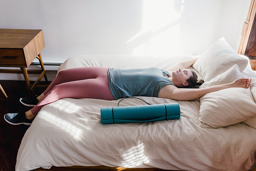 pexels-tim-samuel-6697376 A runner laying in bed dressed to exercise.
