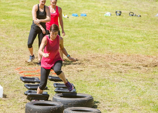 boot camp tire running a lady running through tires with her knee in an awkward position